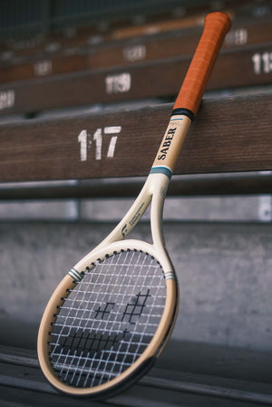 Vintage edition functional tennis Saber  on a wooden bench.